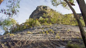 Smooth rocky outcrop rising into sky.