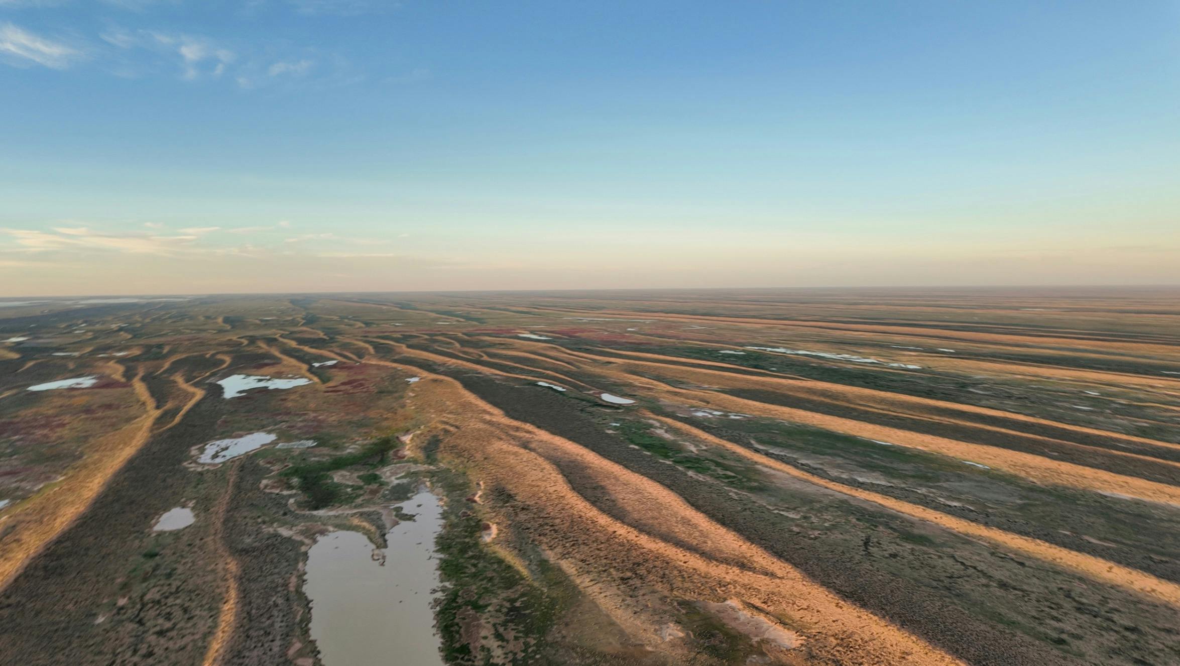 Aerial view of winding inland channels and floodplains across the arid landscape near Lake Eyre