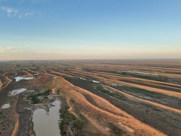 Aerial view of winding inland channels and floodplains across the arid landscape near Lake Eyre Aerial view of winding inland channels and floodplains across the arid landscape near Lake Eyre