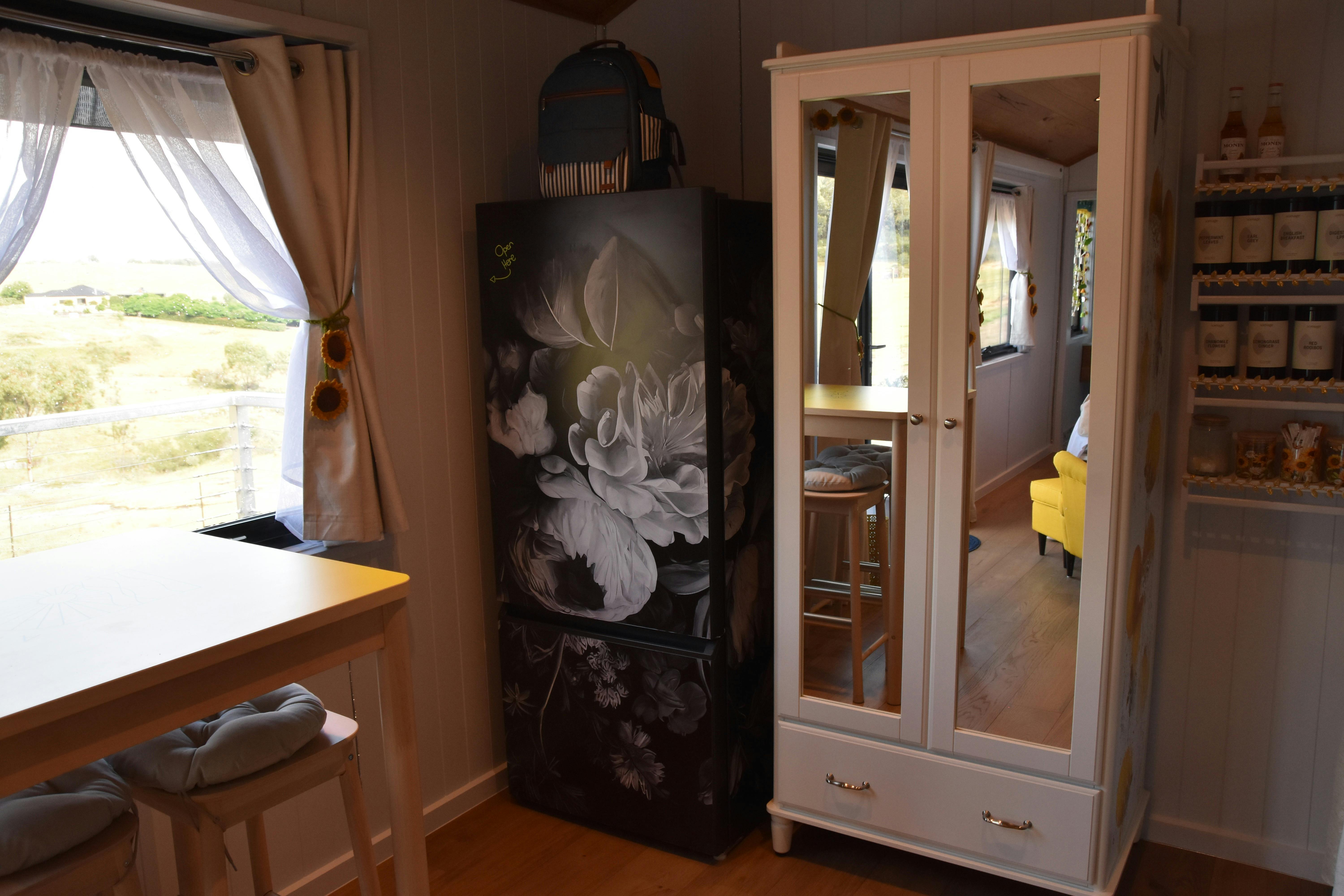 Interior showing fridge, wardrobe, and dining table.