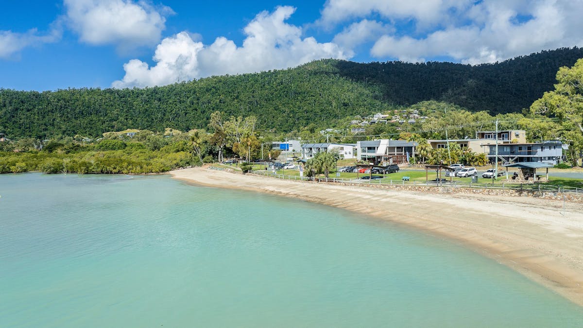 Aerial view of Cannonvale Beach with accessible outdoor gym, playground and picnic areas