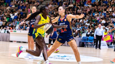 UC Capitals player driving to the basket for a layup during a WNBL game against Adelaide Lightning.