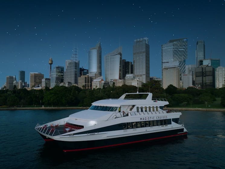 Marvel at the night views of the city skyline from the outer decks of a modern catamaran