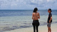 Guests on Green island beach with Ocean Free on its reef site one kilometre away