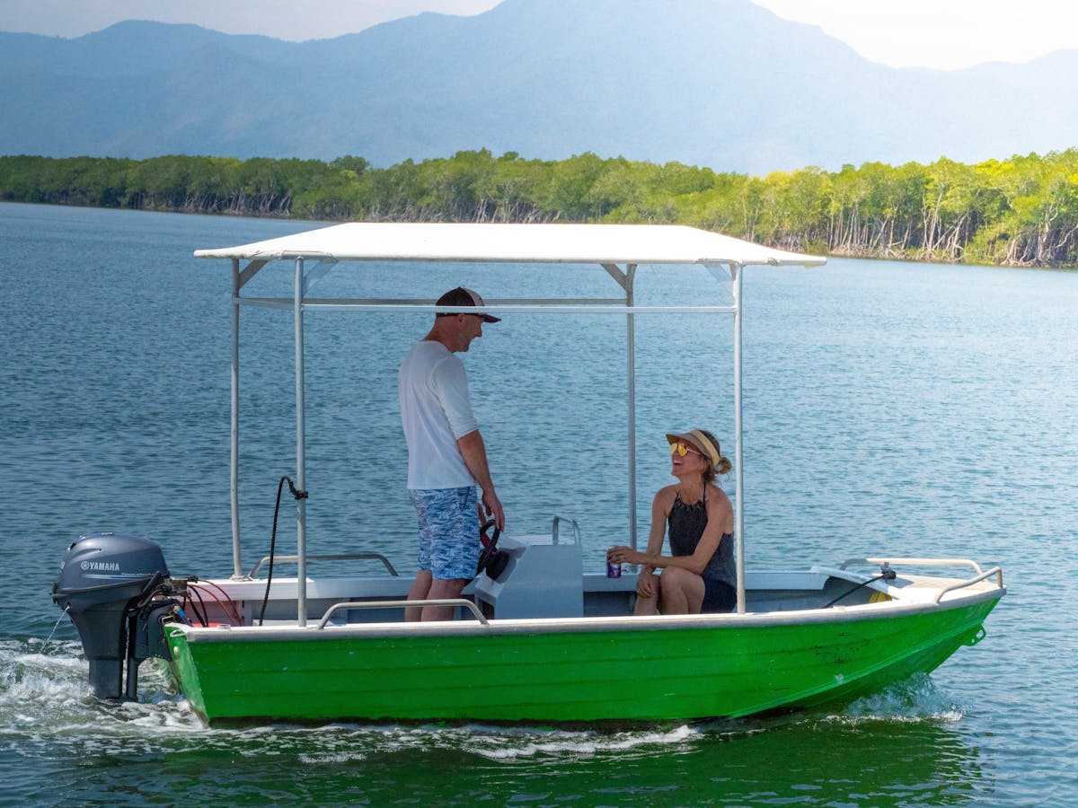 Man and woman sit in a Cairns Boat Hire Tinny heading out for a day on the water Tropical Queensland