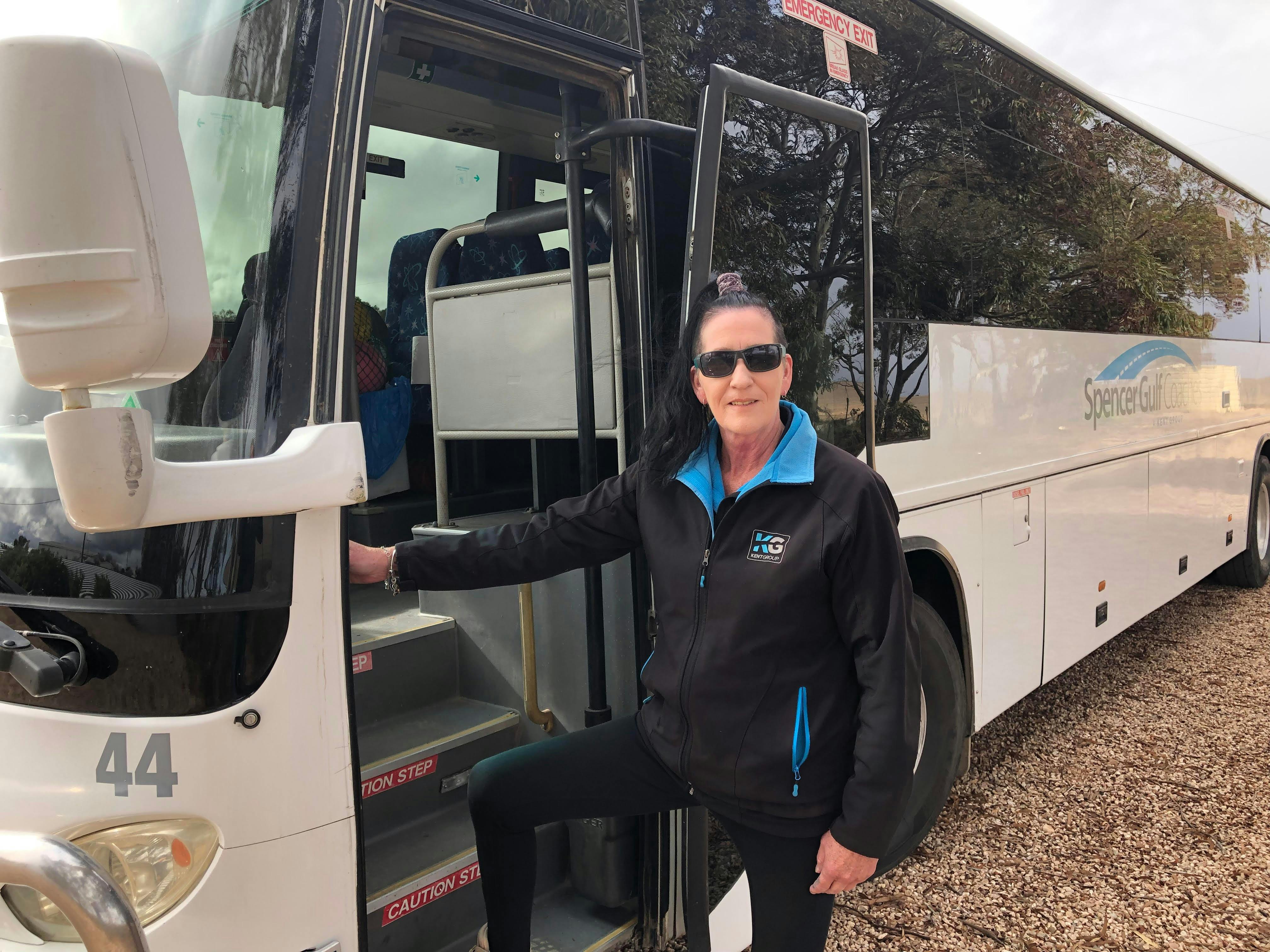 Woman with sunglasses standing at bus door