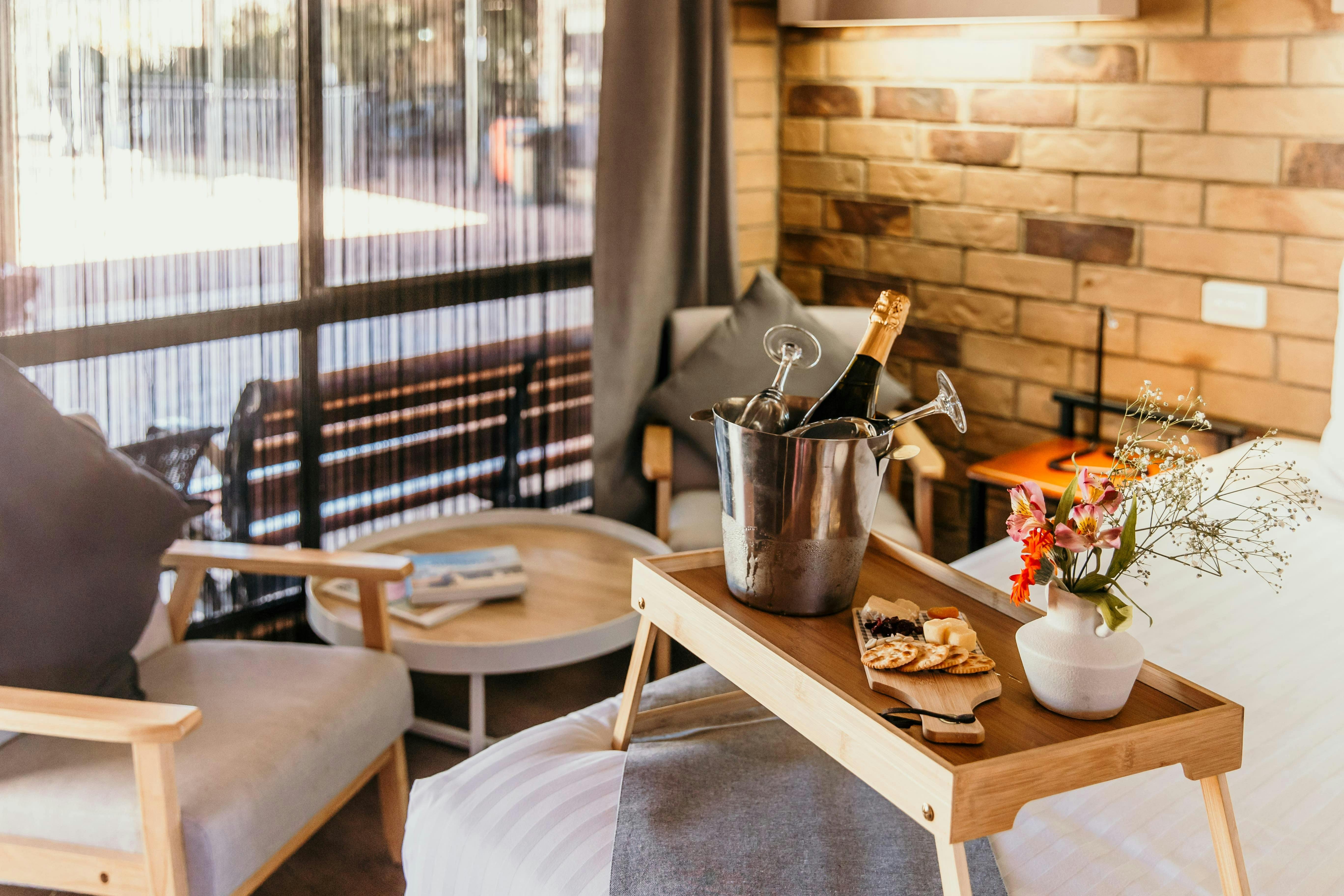 Sitting area and corner of King bed with a robe, cheese platter and champagne ice bucket.