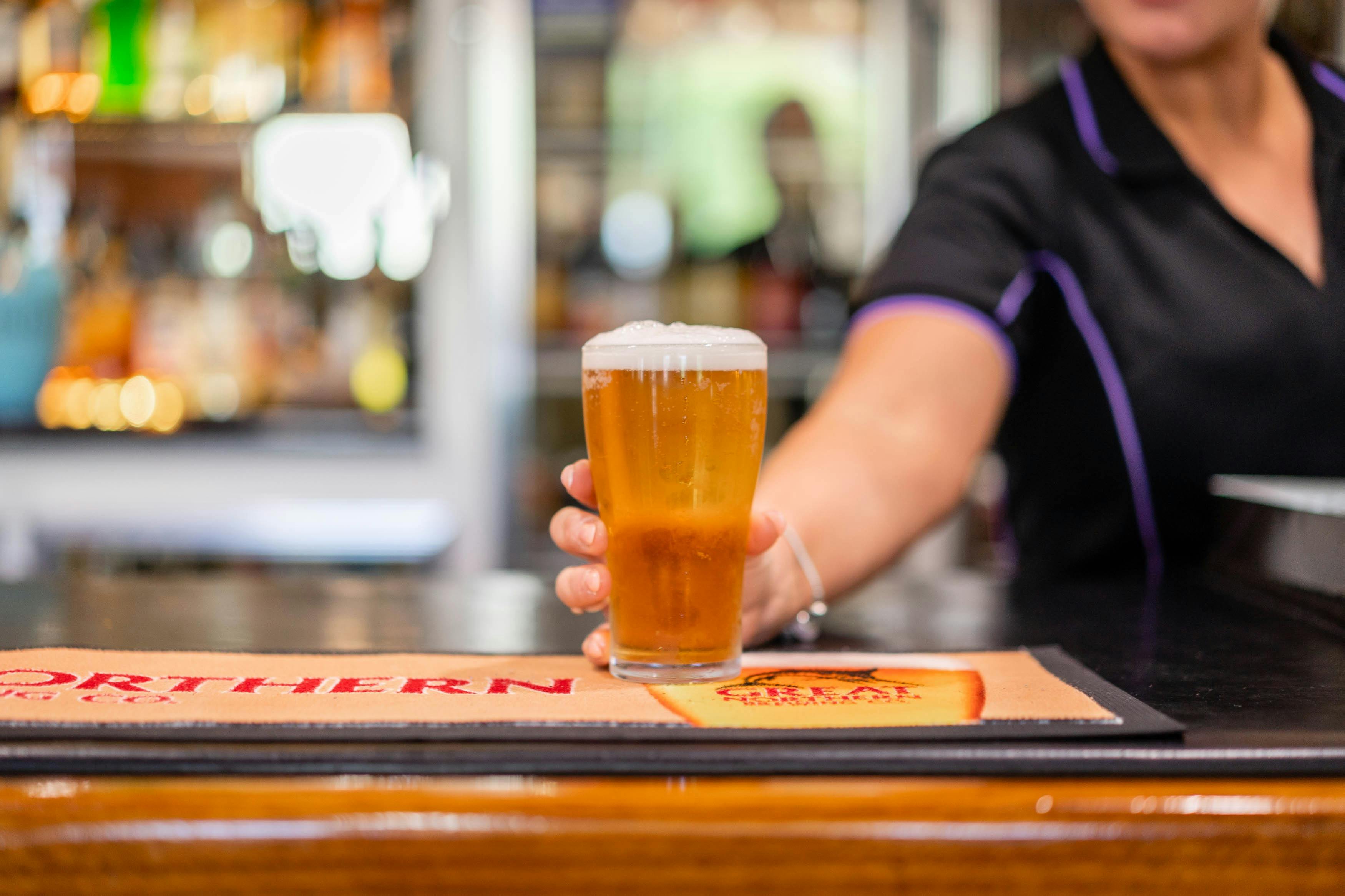 バーでビールを提供するバーテンダー