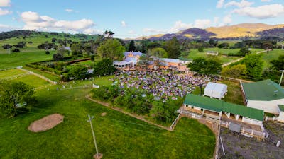 Drone image of Lanyon Homestead with crowd watching concert and buildings in background
