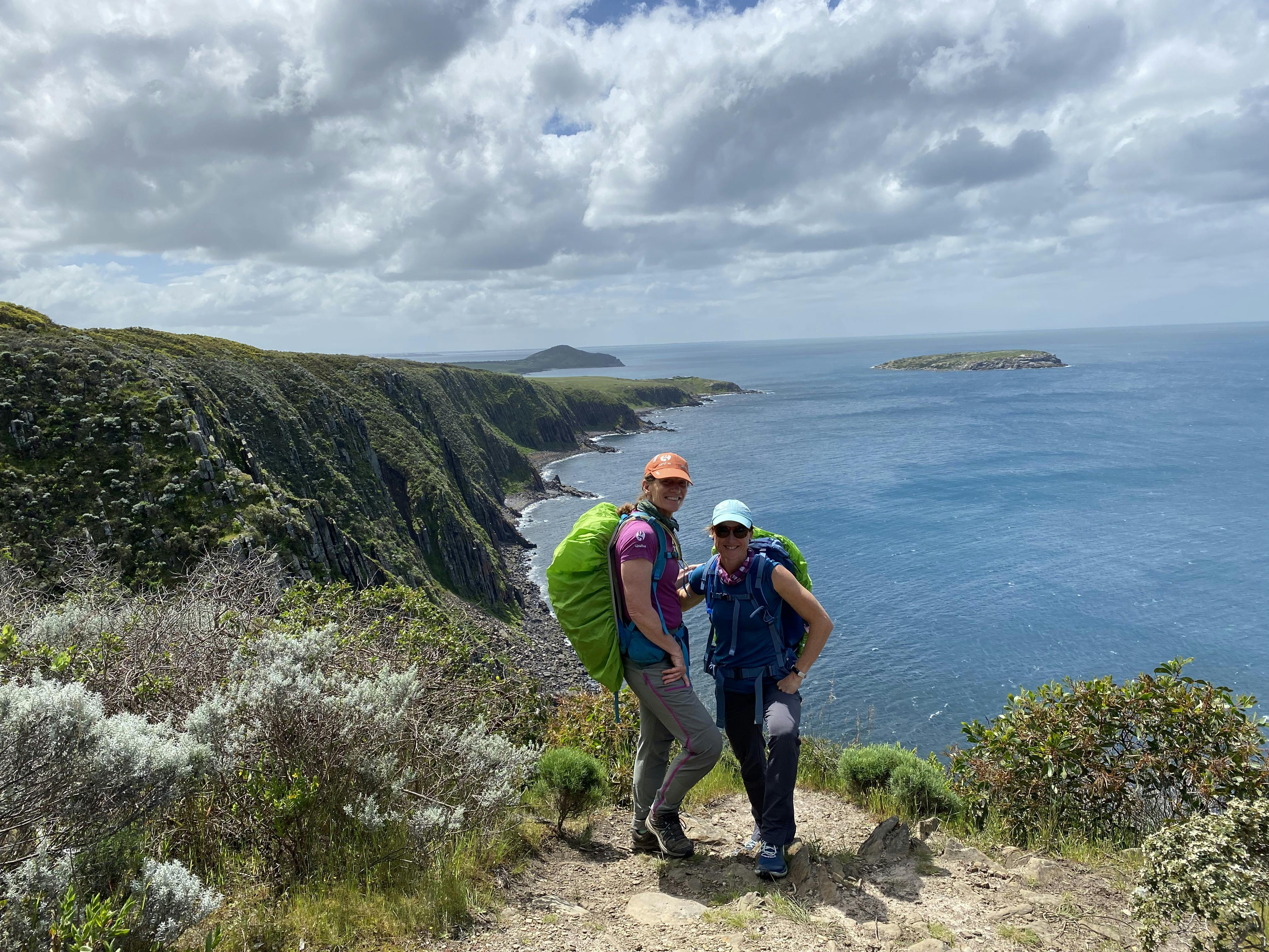 two freinds on coastal trail with a view
