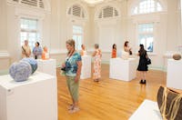 Visitors are looking at Yarrabah Ceramics exhibiton by Yarrabah Art Centre.