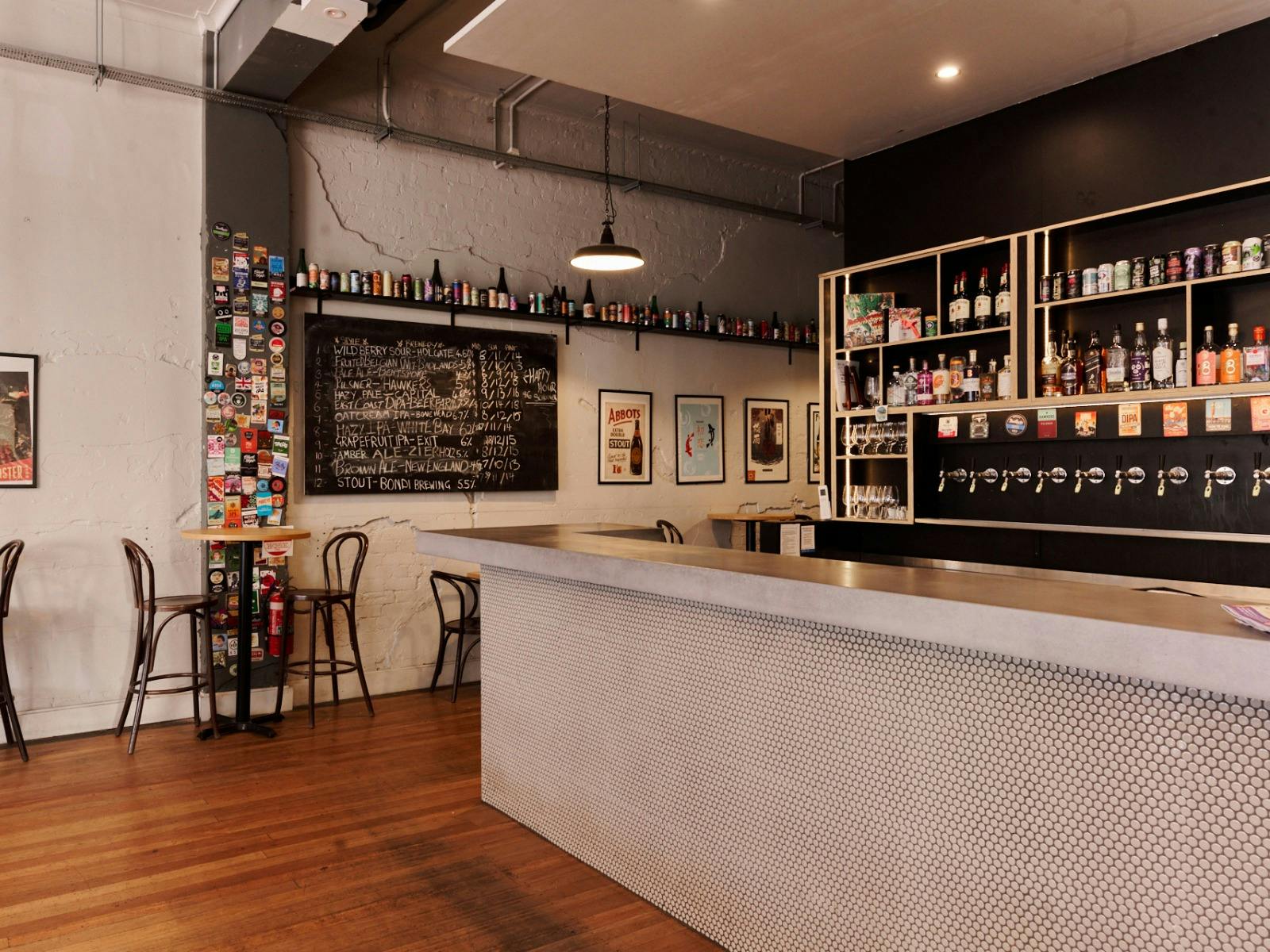Bar with beer taps behind on the wall and bar tables against opposite wall