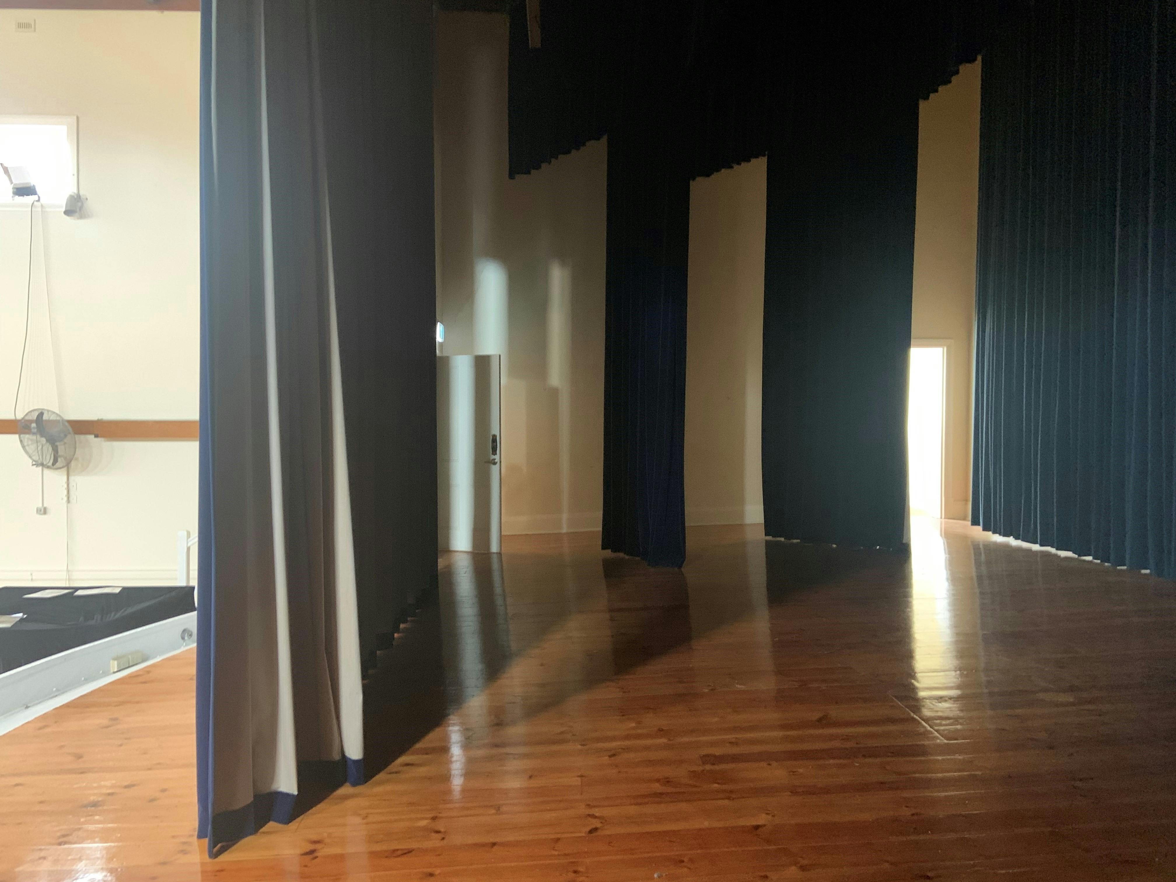 A large stage full lighting and curtains