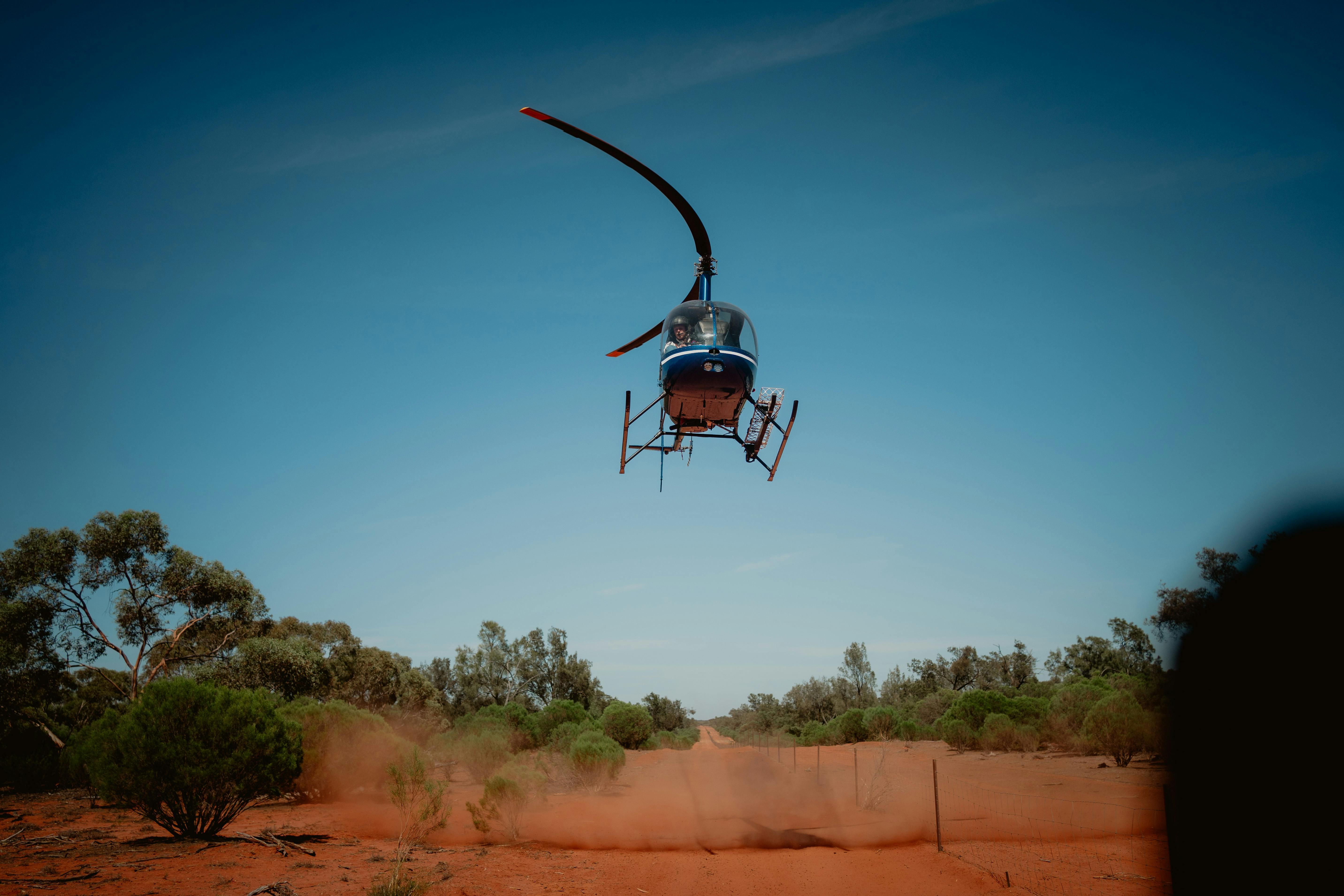 Helicopter flying low over outback setting