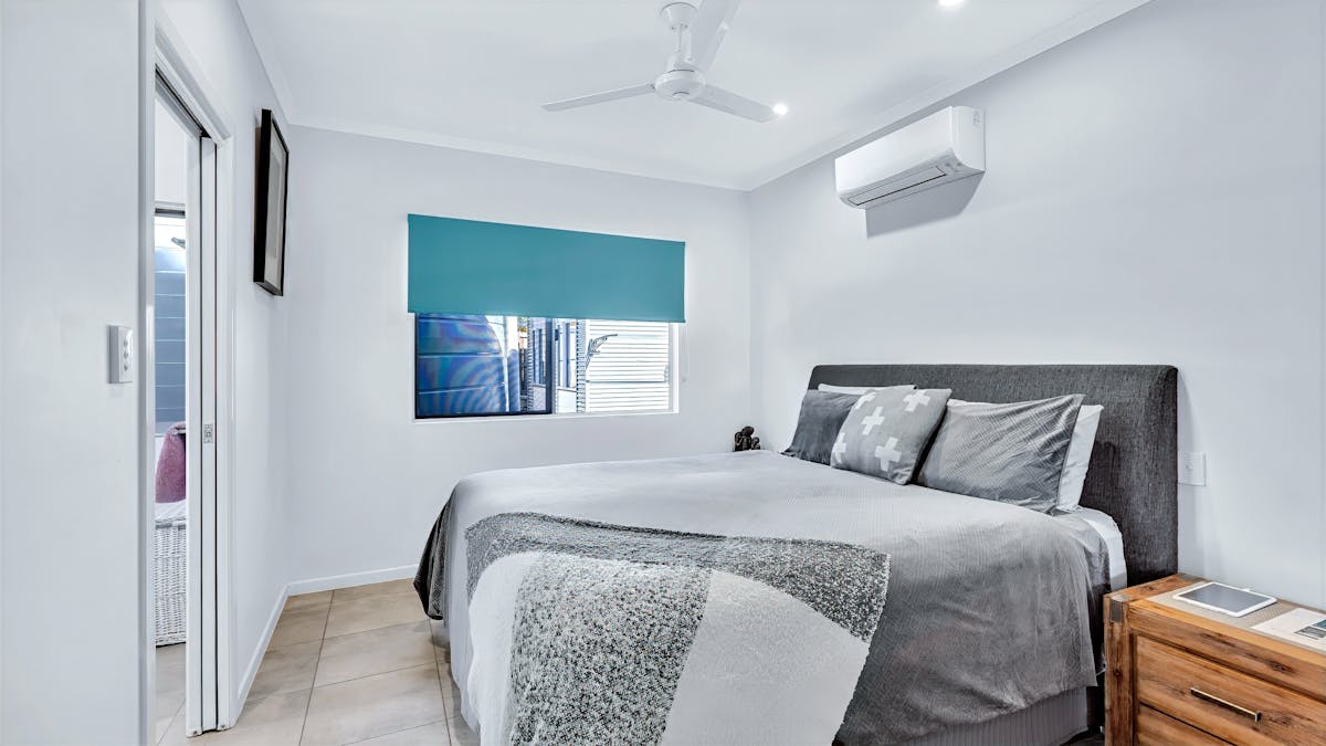 “Family-friendly holiday home bedroom with queen bed and air conditioning in Hideaway Bay “Family-friendly holiday home bedroom with queen bed and air conditioning in Hideaway Bay