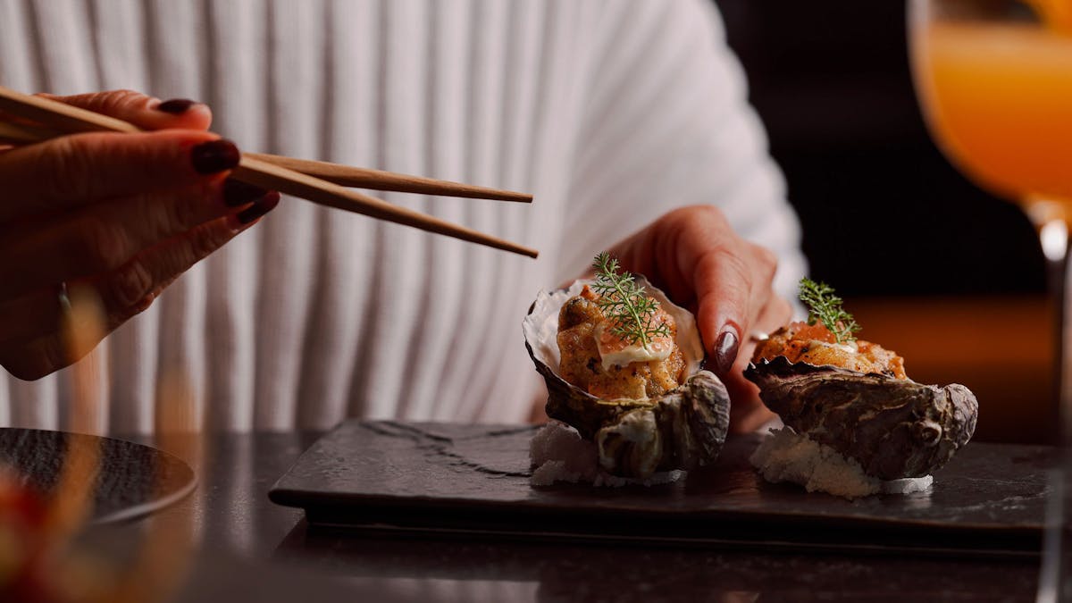chopsticks picking up a fried oyster