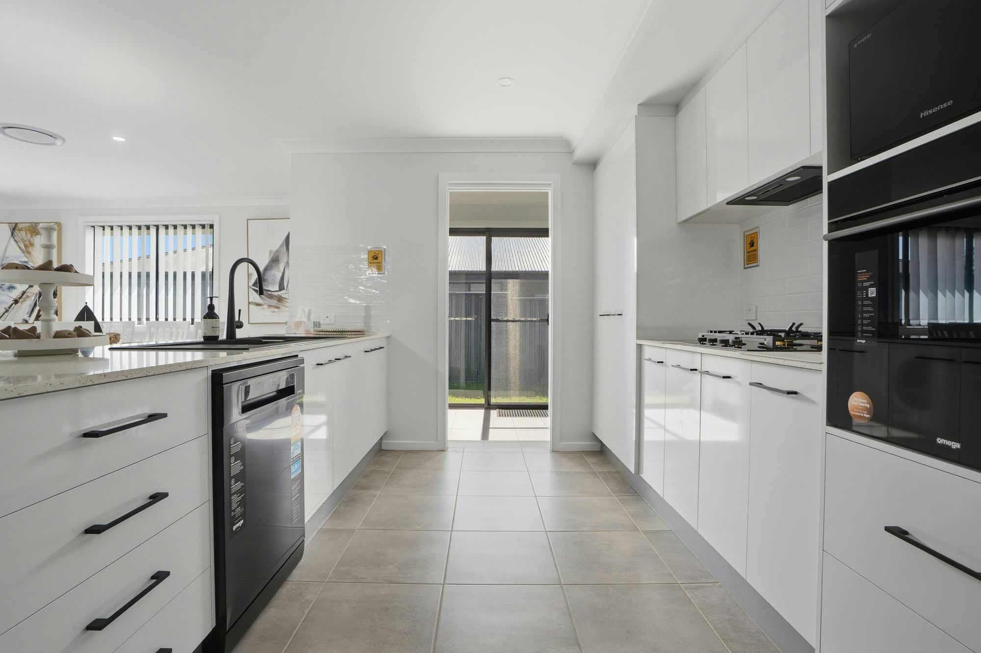 Large white kitchen with tiles and modern white cabinets, modern appliances