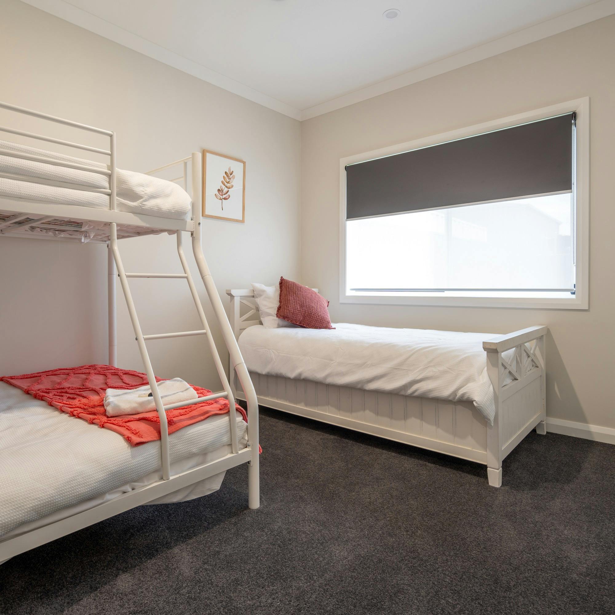 이층 침대(더블 바텀 싱글 탑)와 싱글 침대를 보여주는 레드 침실.