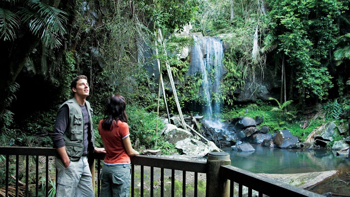 Couple standing on viewing deck with falls in background.