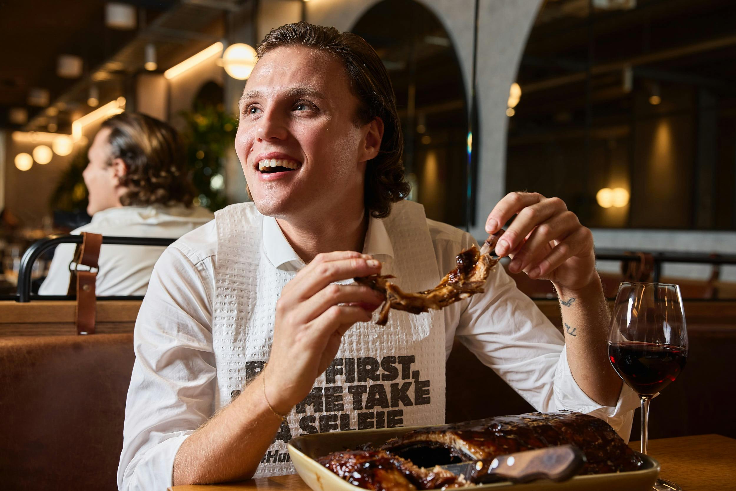 Hurricane's Grill & Bar - Bondi Beach smiling diner wearing a bib and holding ribs