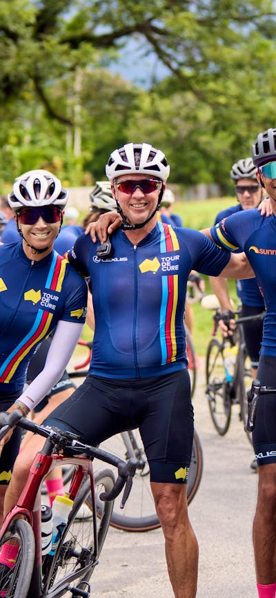 Four cyclists casually on bikes not riding inc. Ch7's Mark Beretta at the end of Signature Tour '25