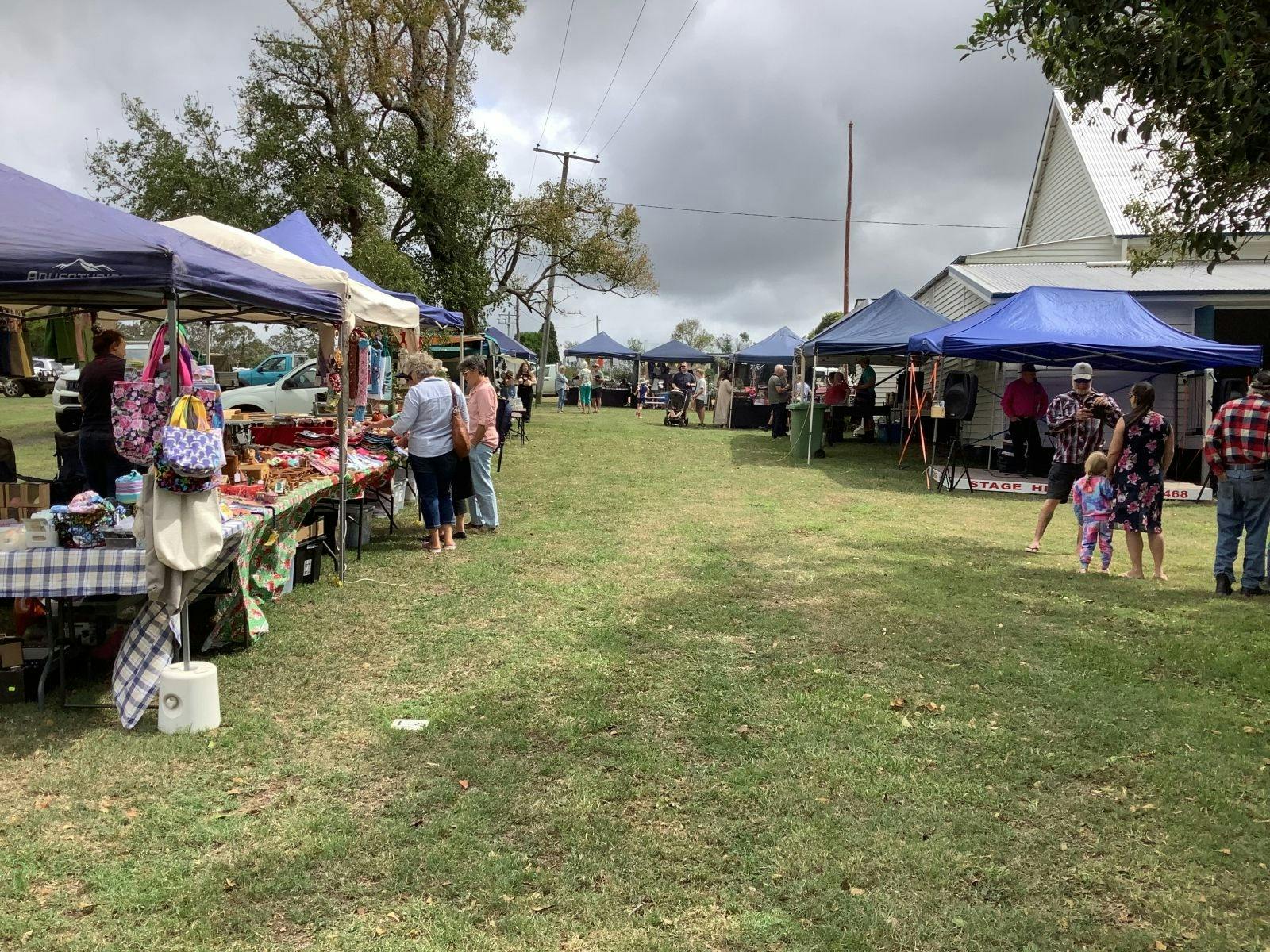 Photo of grassy area with pop up gazebos and people milling about.