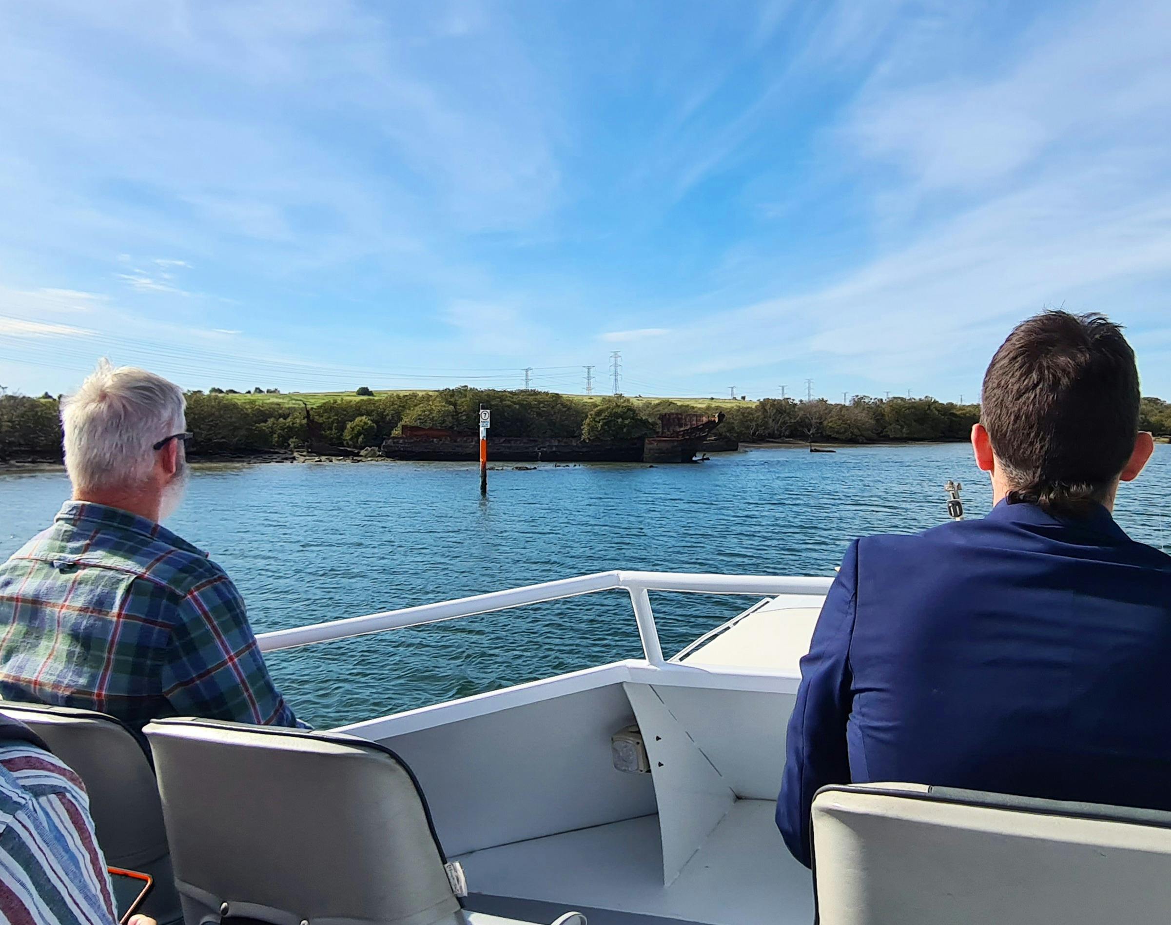 Two people look over at a series of scuttled vessels