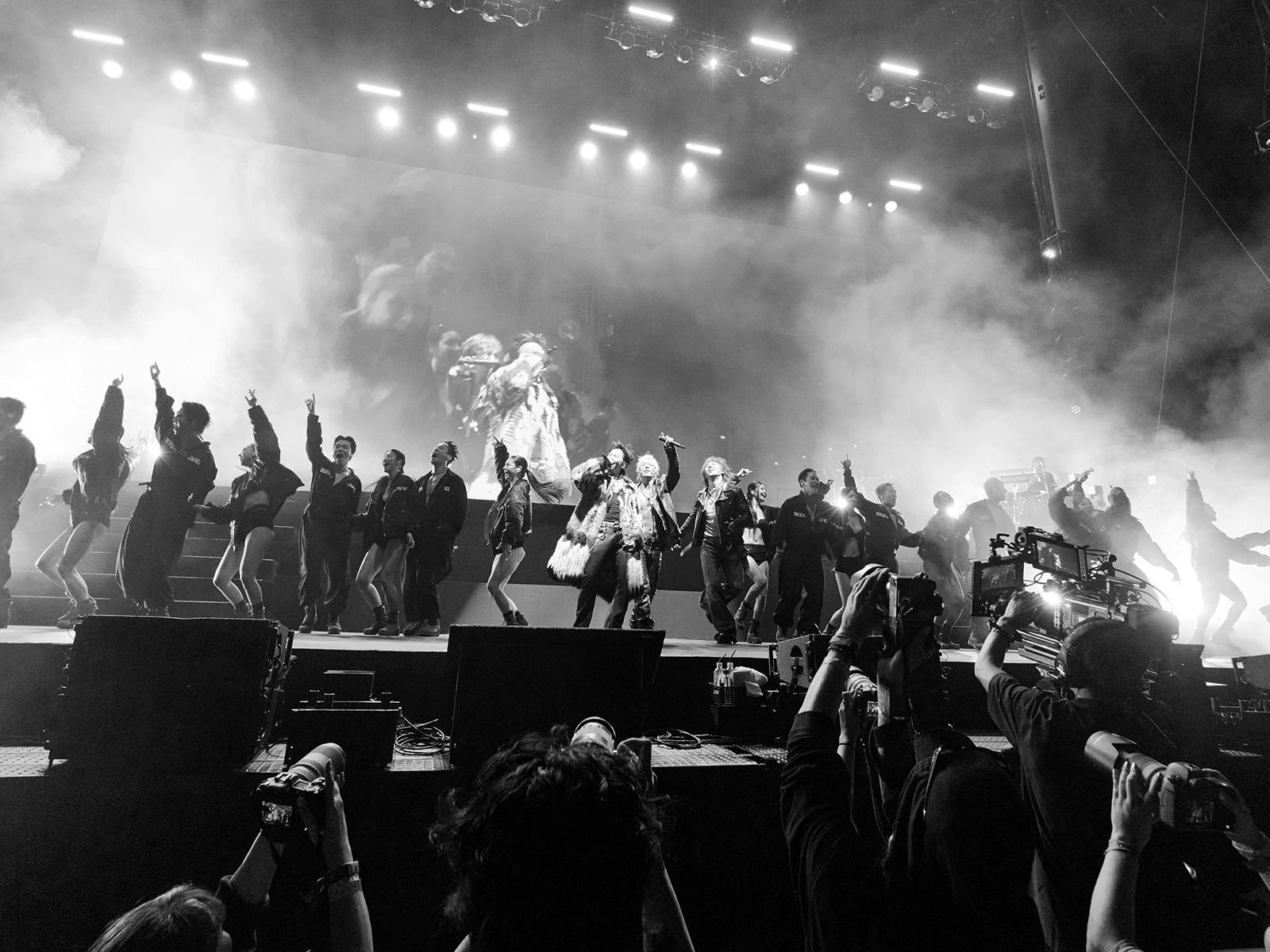 Black and White stage photo. Kpop Legends BIGBANG stand in front of a Coachella crowd.