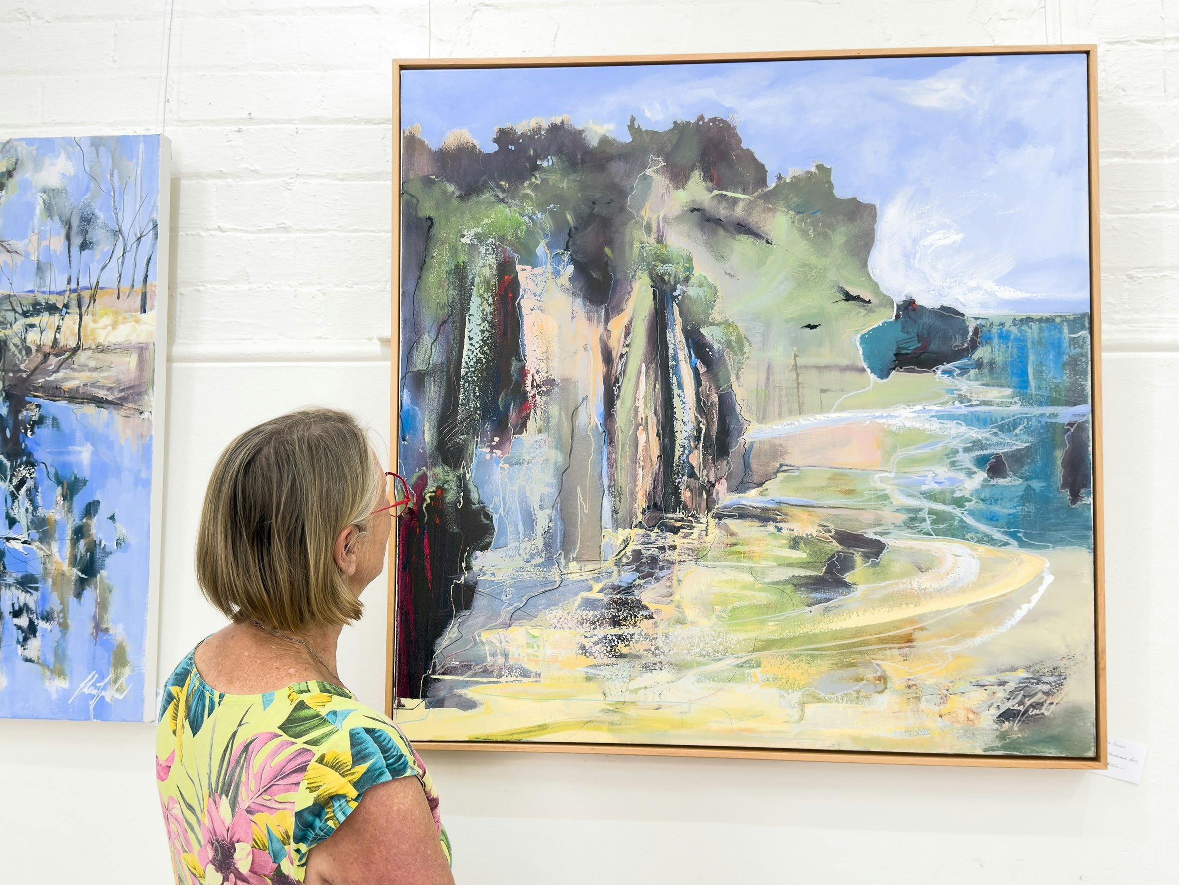 Woman looking at a painting in a gallery
