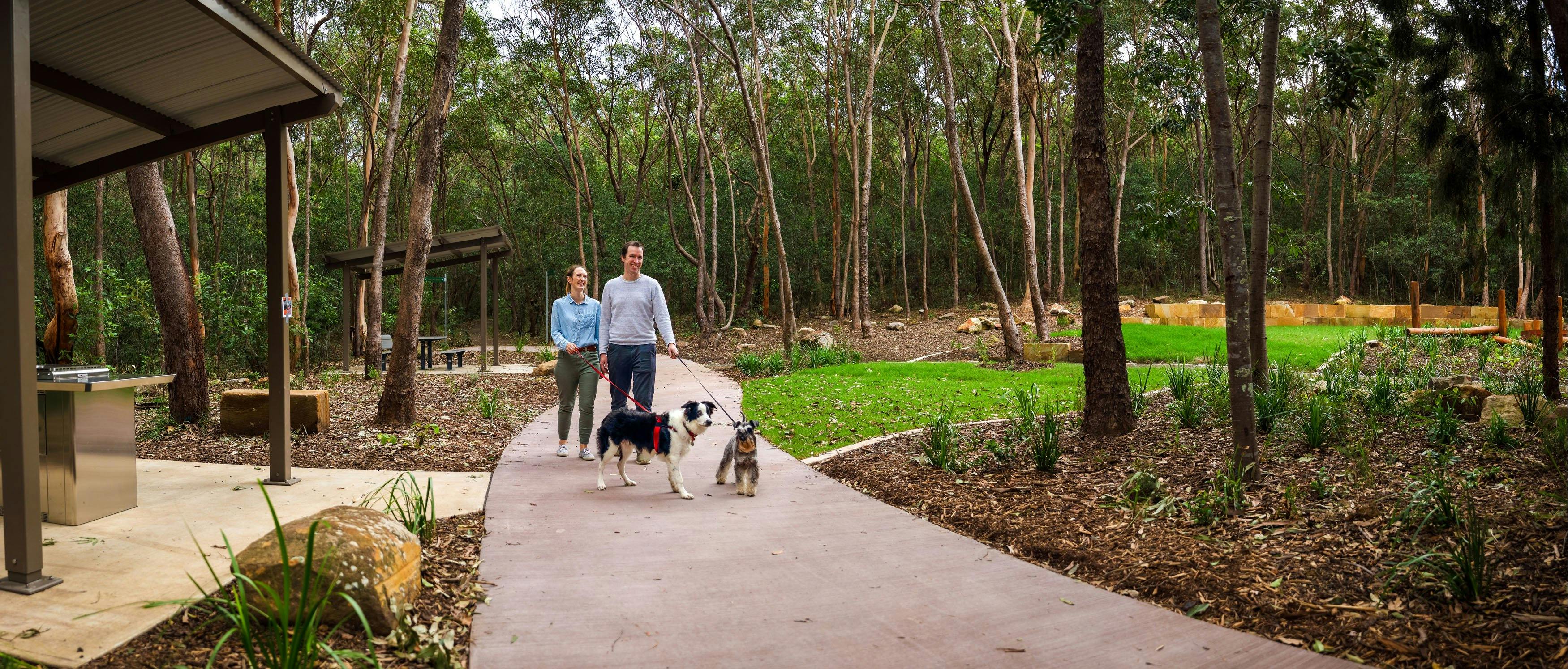 People walking dogs on path through conservation estate