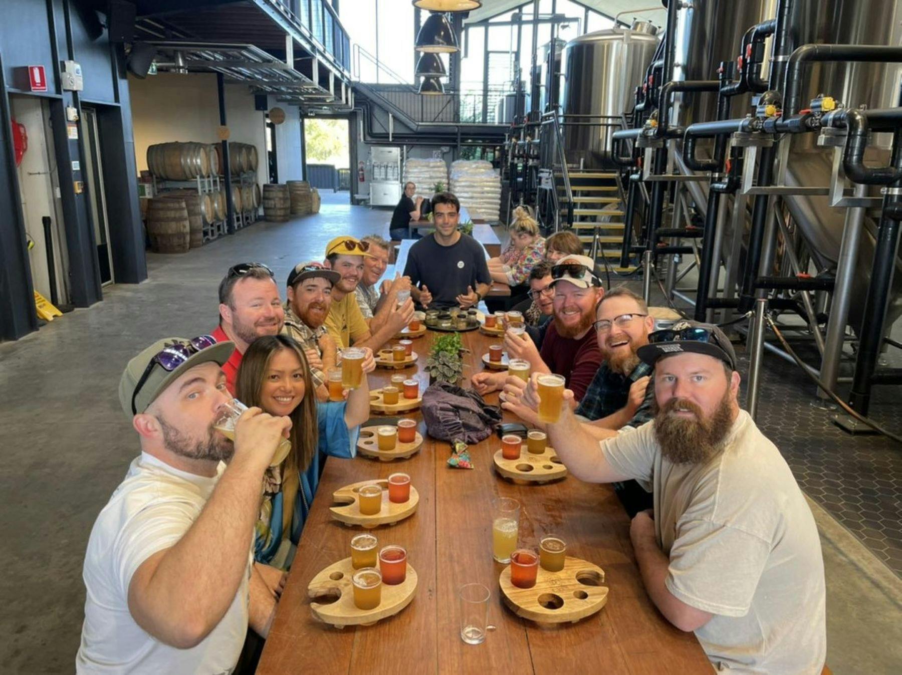 people sat at a table inside brewery with beer tastings