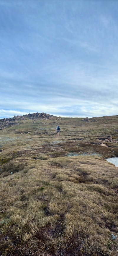 A few alpine bogs across rolling terrain with an overcast sky.