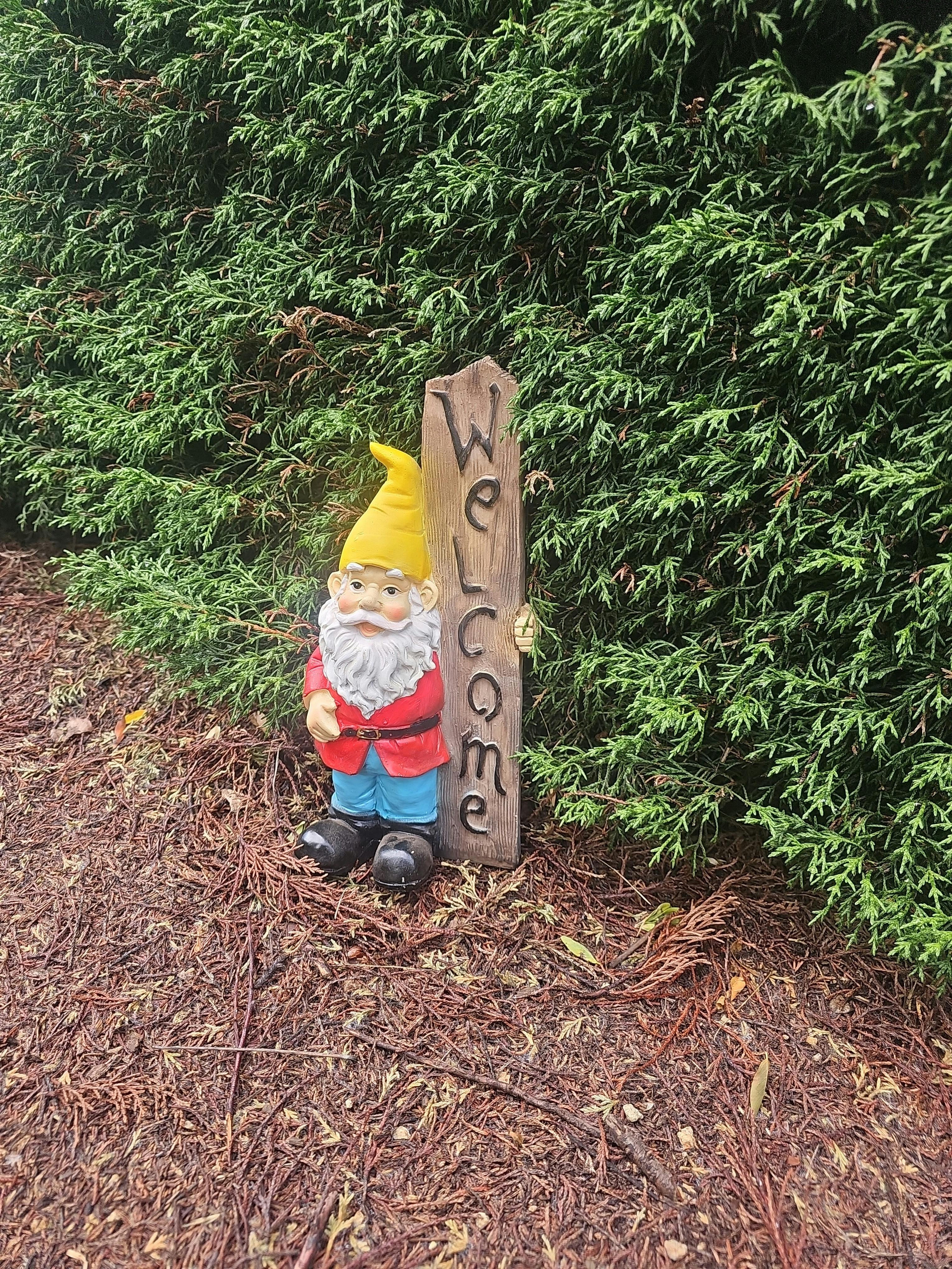 A gnome next to a welcome sign