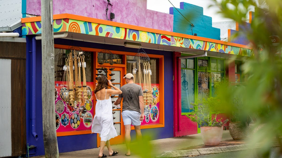 A couple passing by a colorful shop on the street