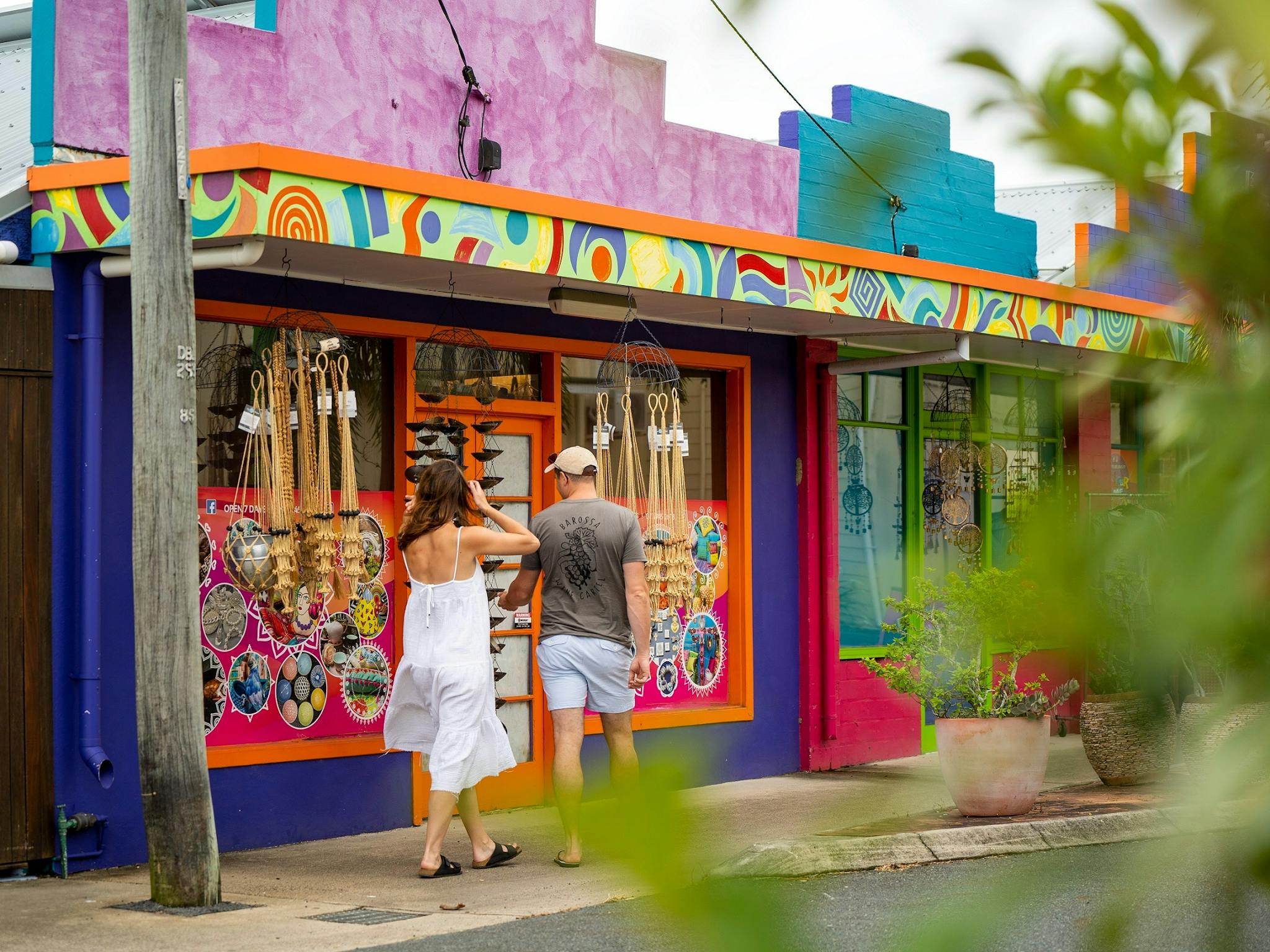A couple passing by a colorful shop on the street