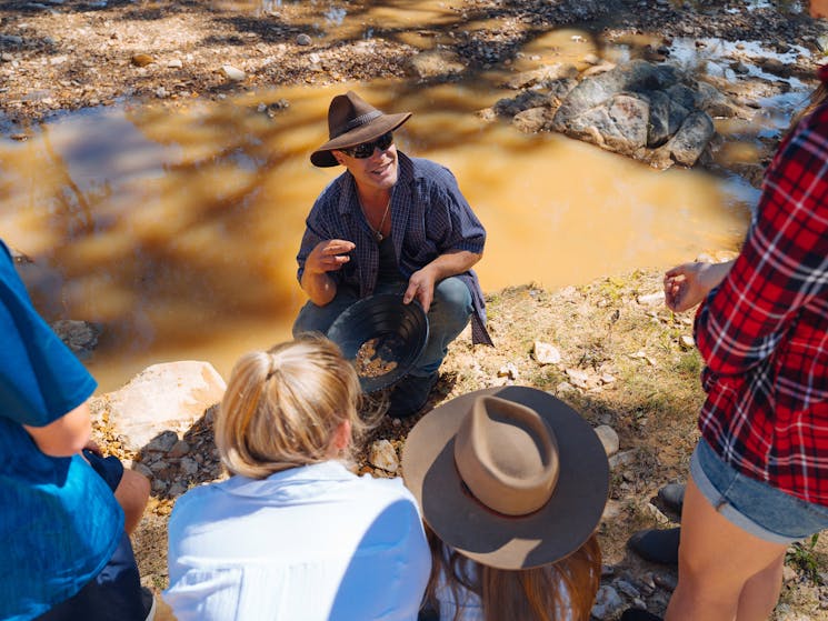 Jhob Drinkwater teaching a tour group to pan for gold.