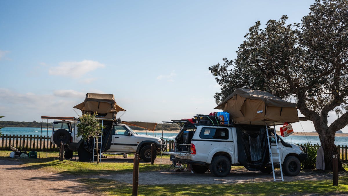 Image of 2 rooftop tent set ups on beach from sites overlooking the ocean and river at cotton tree