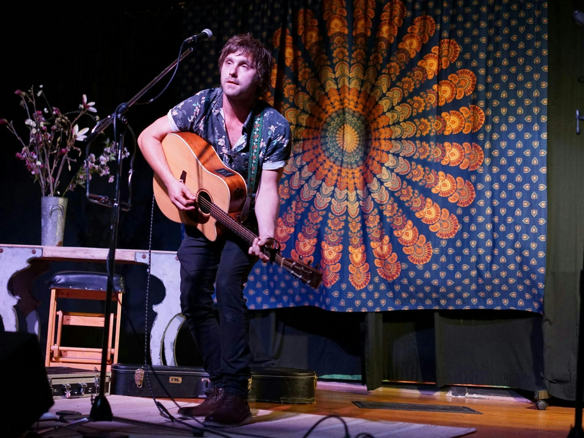 Milo green playing guitar and performing on stage