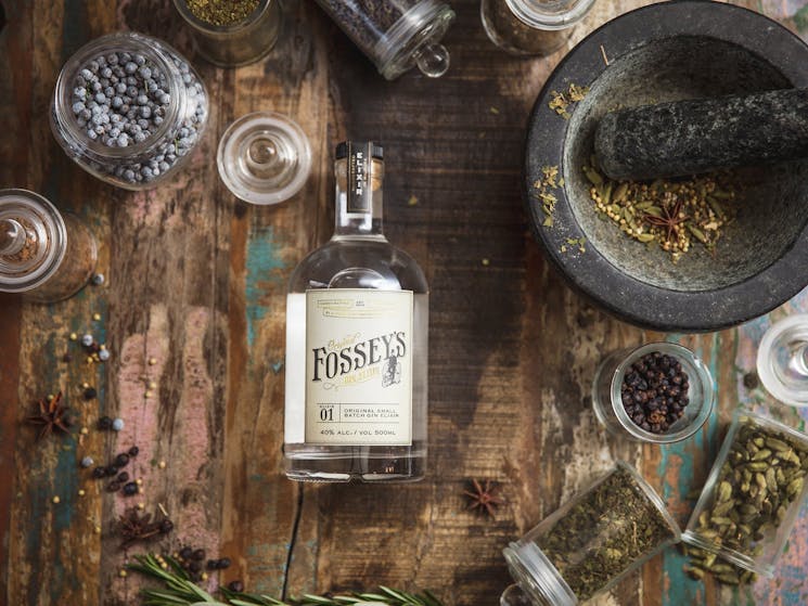 bottle of gin surrounded by different botanicals contained in the gin