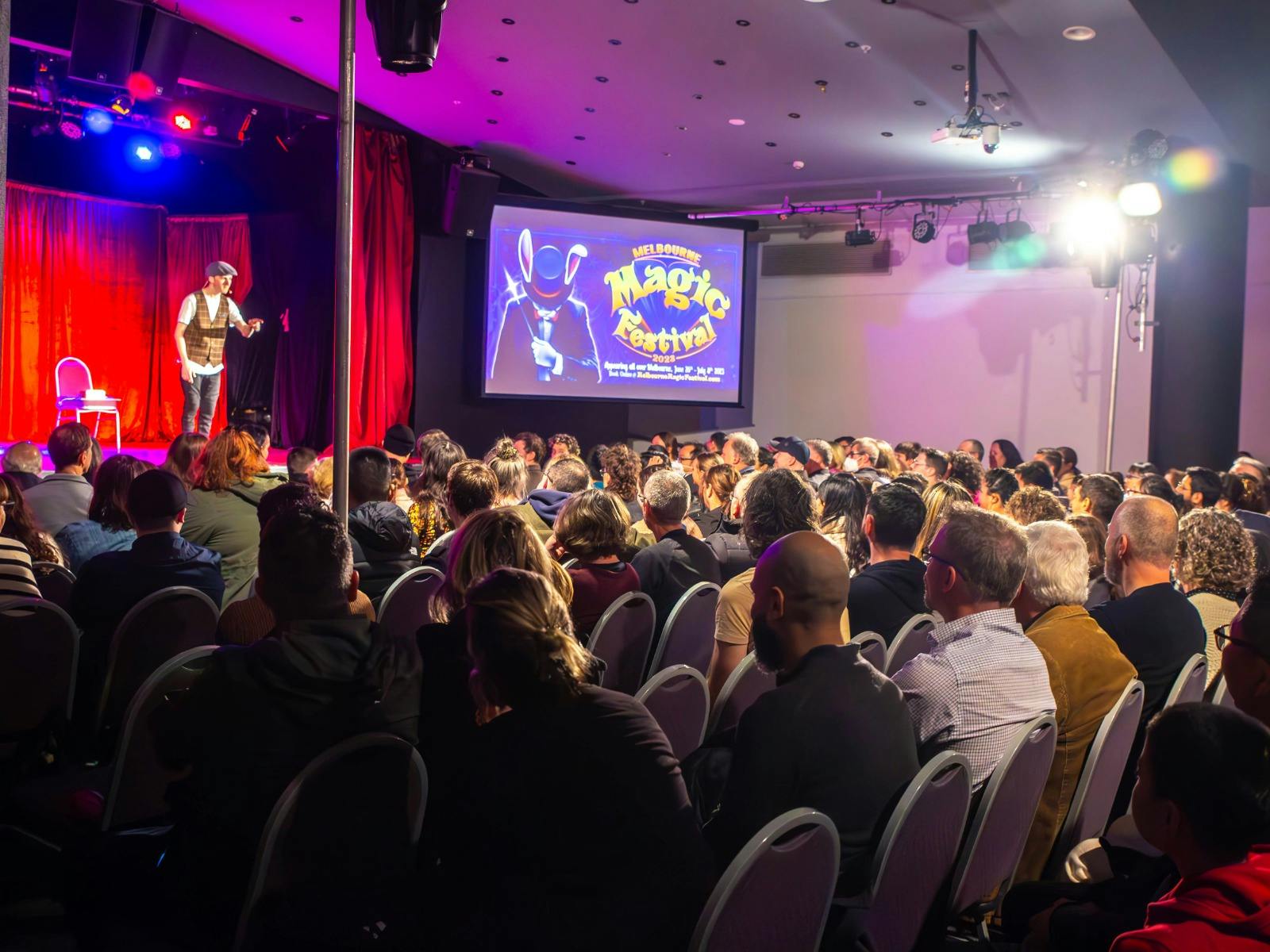 Aiden on stage in front of large audience at the Melbourne Magic Festival.