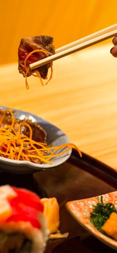 Hand holding japanese food in chopsticks