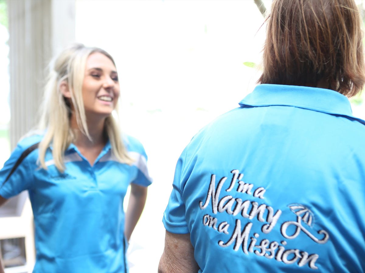 Two Nannies showing their uniforms front and back