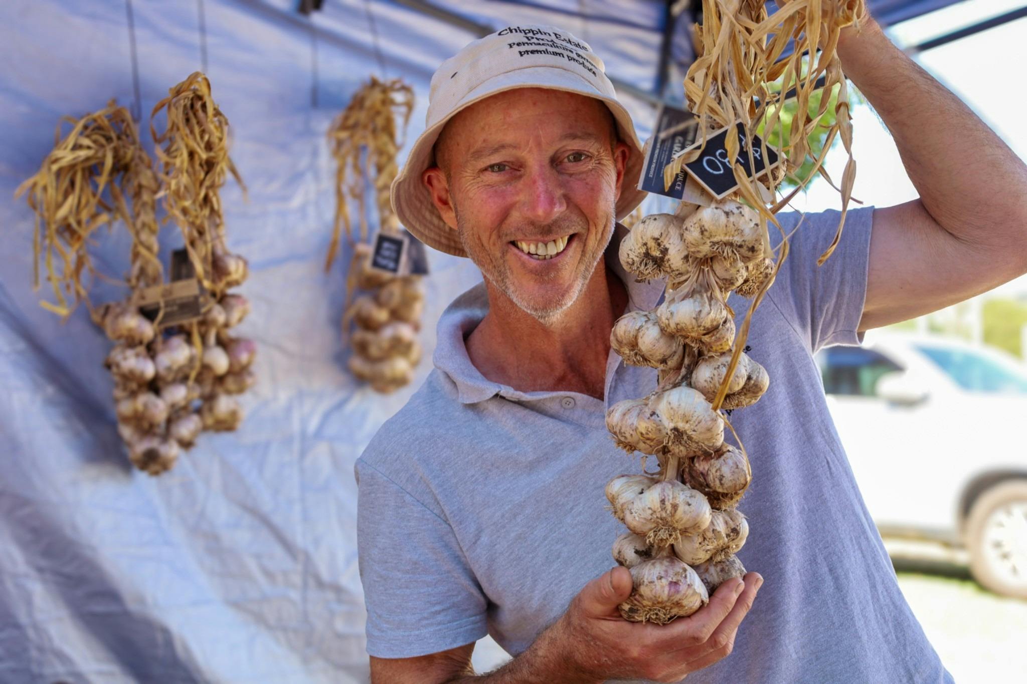 Man holding a bunch of garlic and smiling