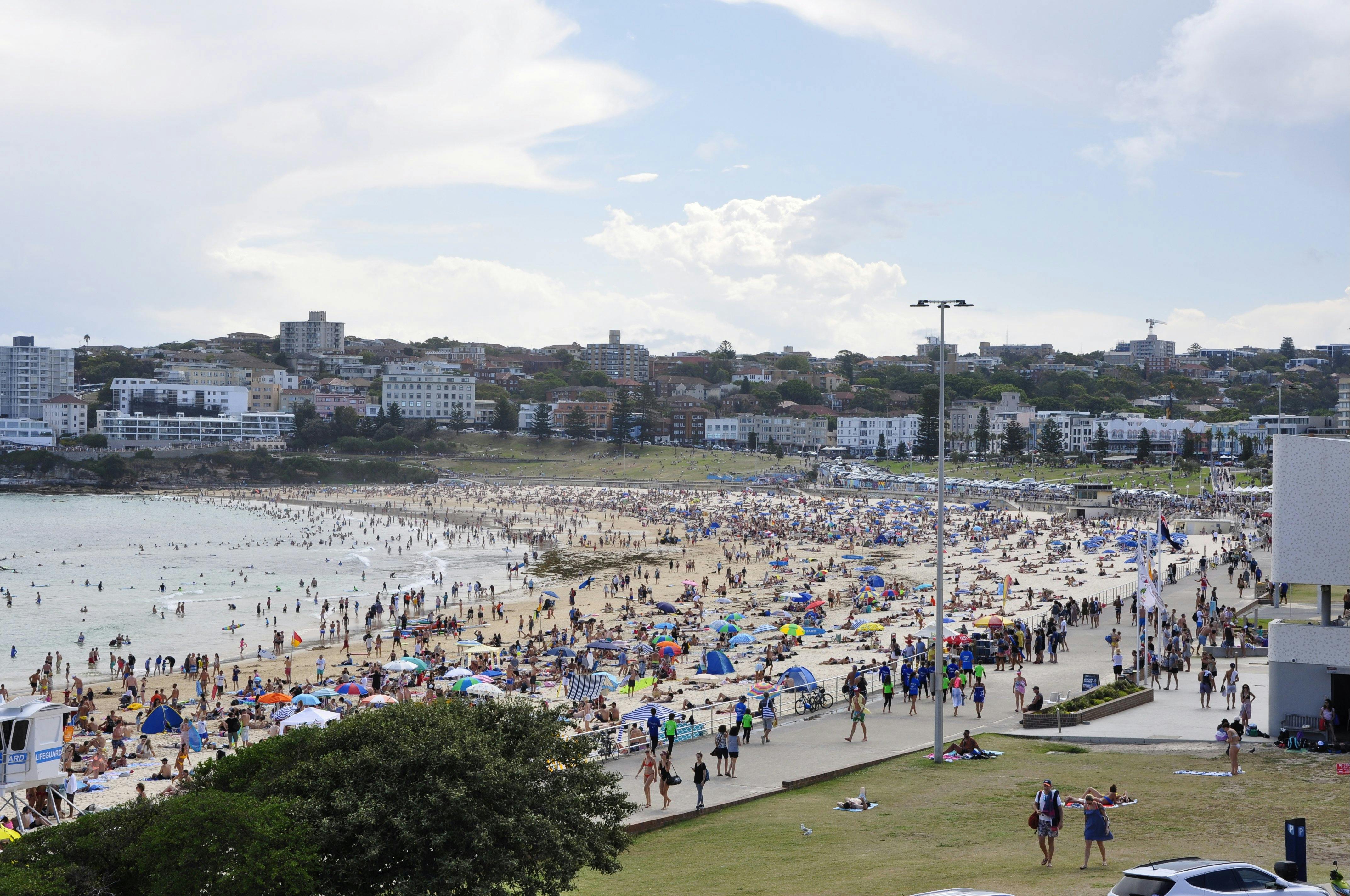 Another stop of Sydney tour bus at Bondi Beach. Summer. Weekend. The beach is teeming with people.