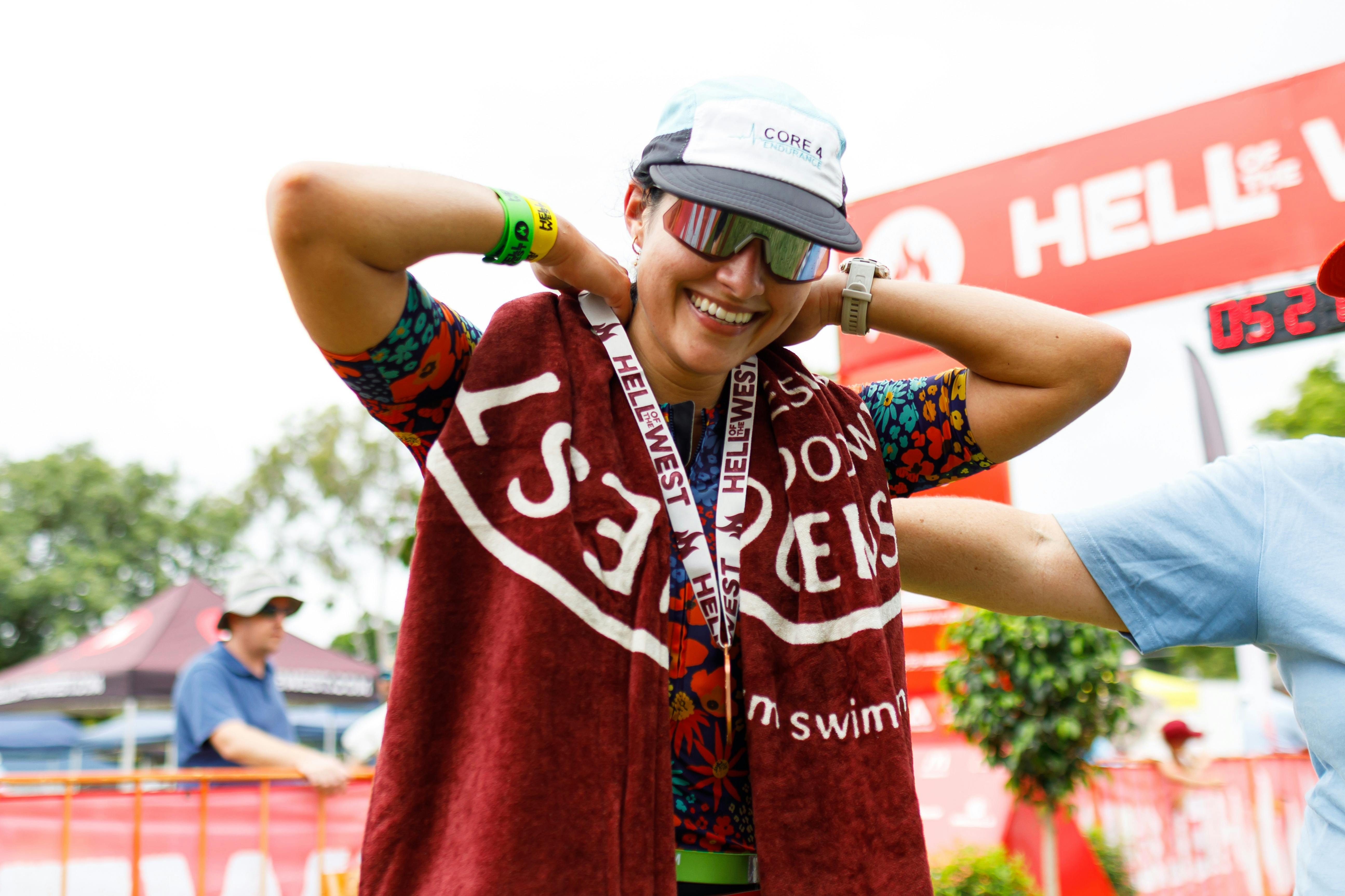 Competitor is all smiles after crossing line and receiving her medal and towel