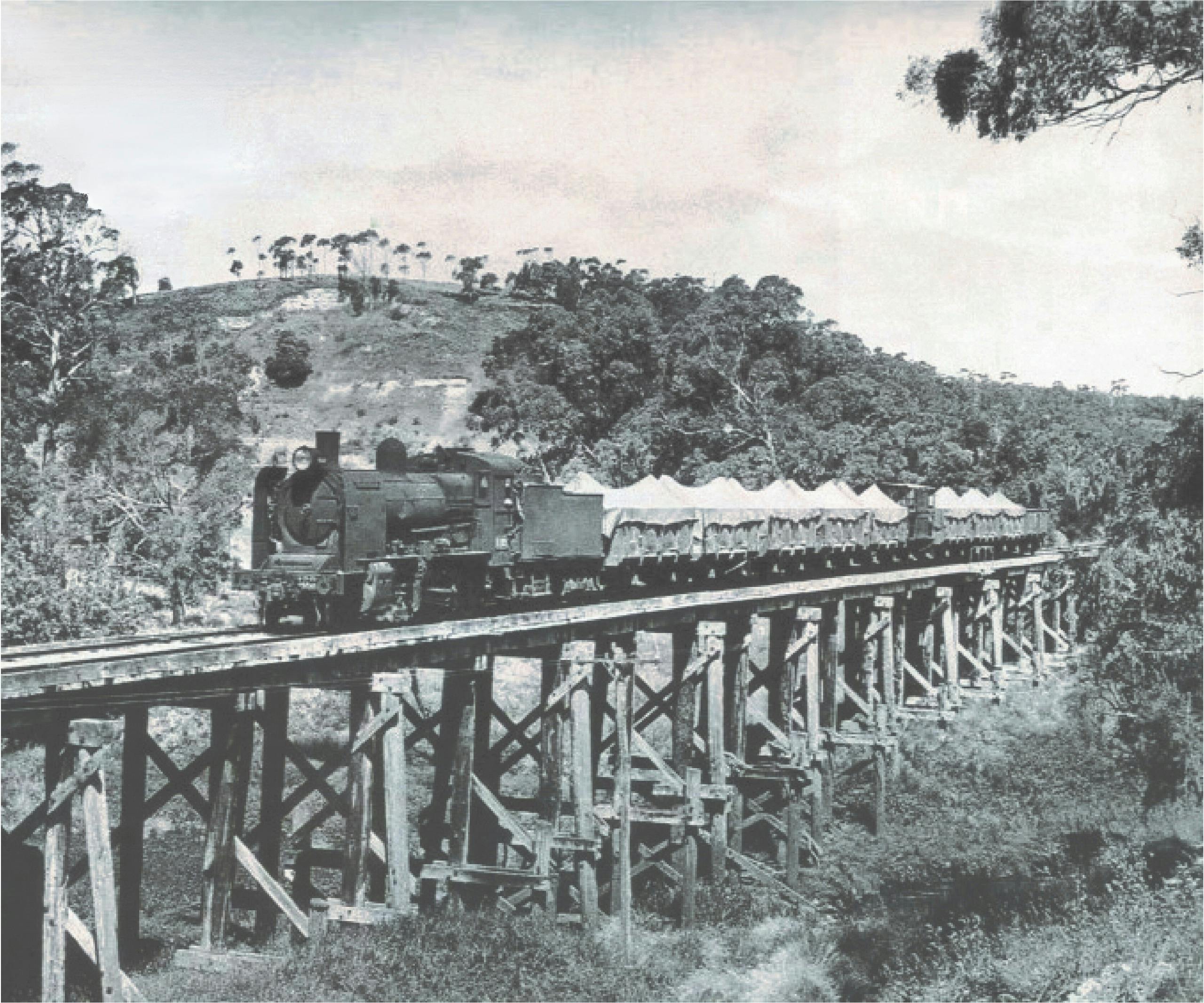 Historical image of a steam train crossing the trestle bridge