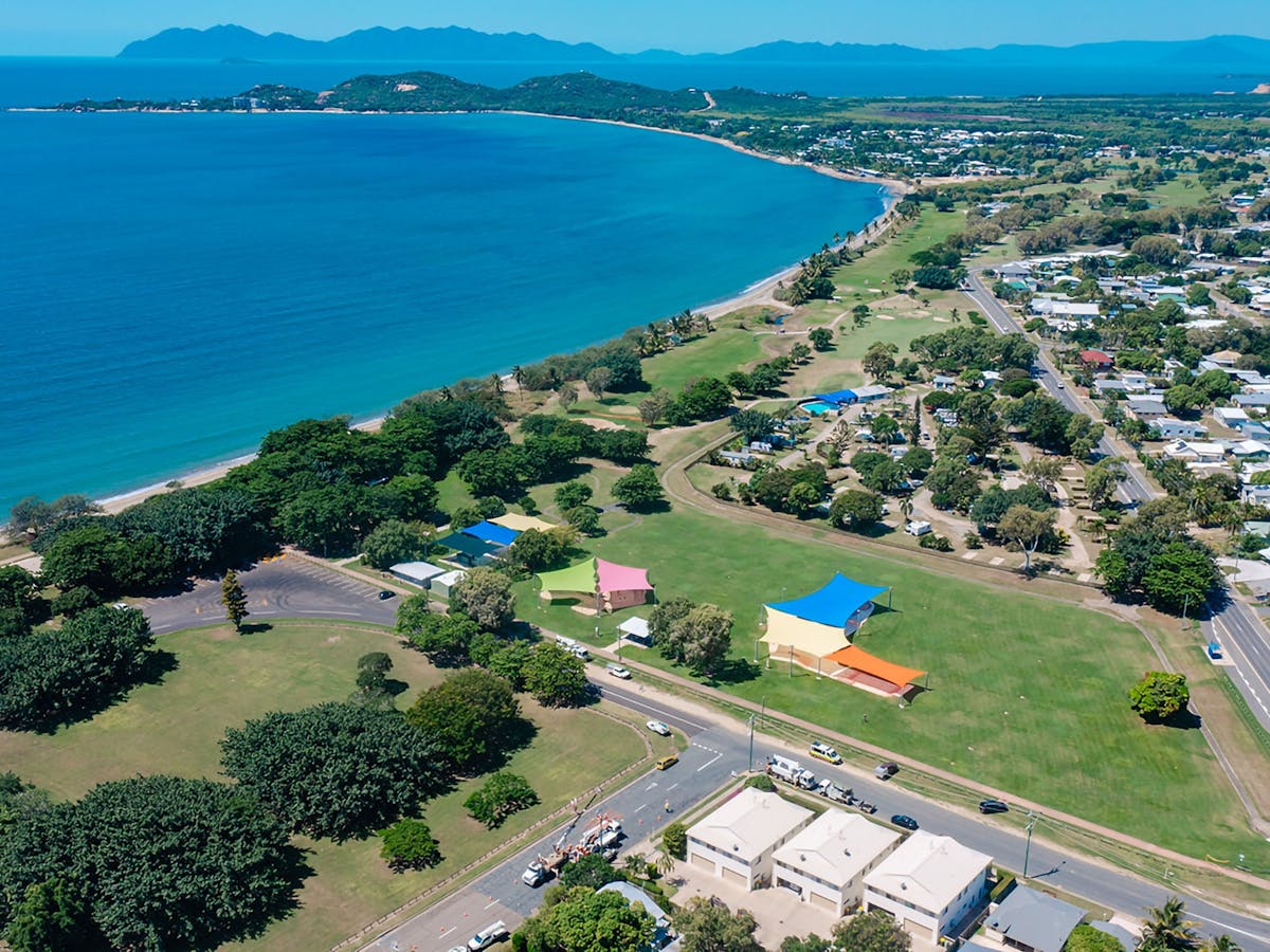Aerial view of the coastal town of Bowen featuring a beach in the foreground.