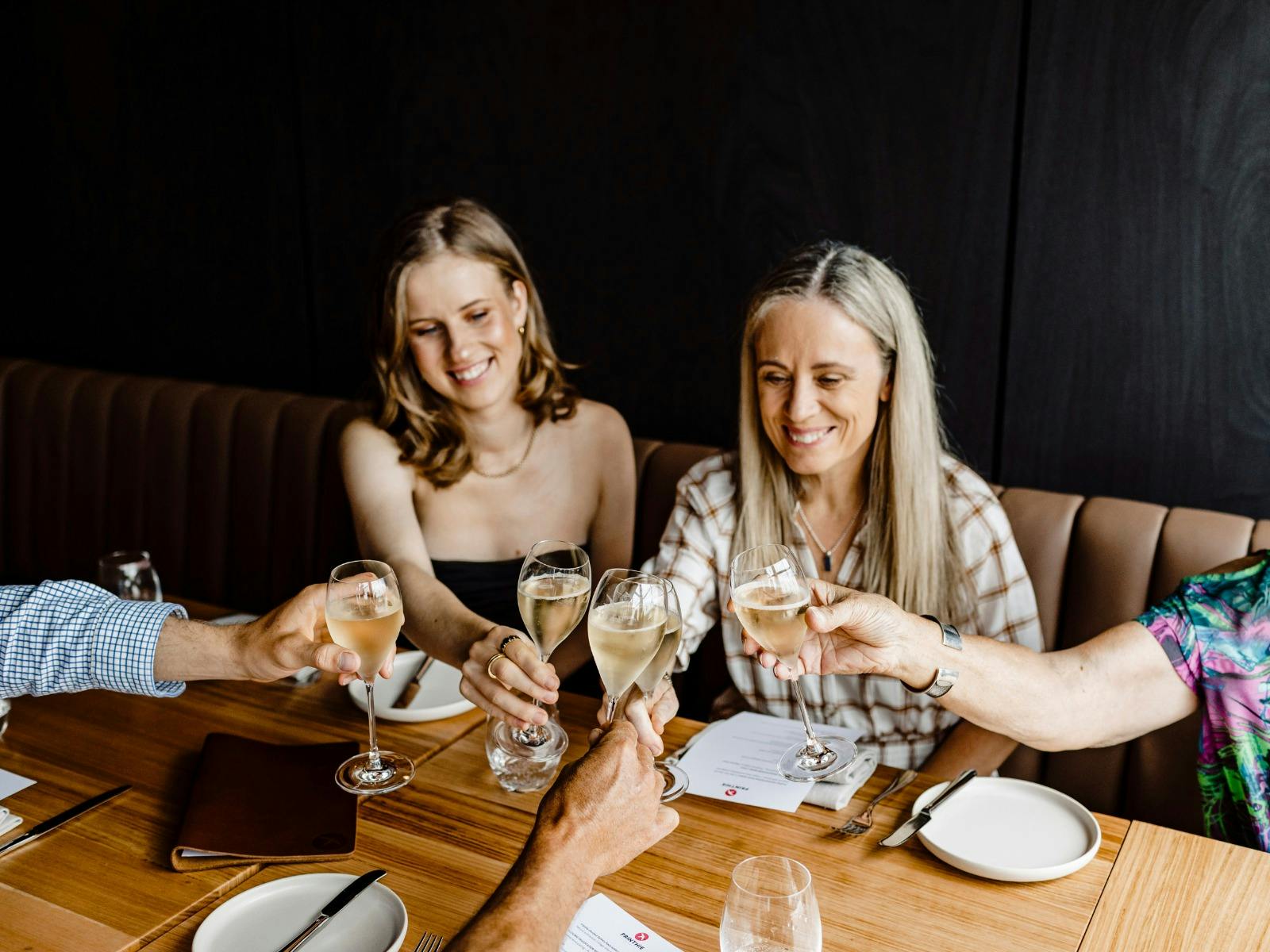 Group of people with raised glasses sitting at Printhie Dining