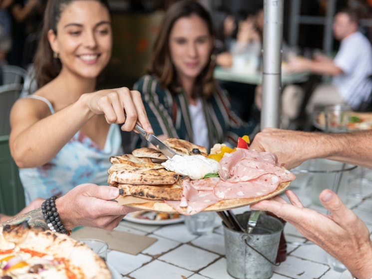 Couple enjoying food and drinks with friends at The Beresford, Surry Hills