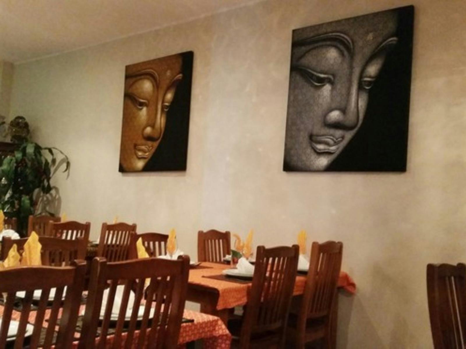Images of chairs and photos on the wall of restaurant.